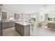 Open-concept kitchen features an island, stainless steel appliances, and a view of the outdoor dining and living areas at 1671 Ruby Ln, Lake Alfred, FL 33850