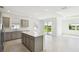 Open-concept space with a large island and stainless appliances flows seamlessly from the kitchen to the bright living area at 1671 Ruby Ln, Lake Alfred, FL 33850