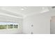 Bright main bedroom featuring a tray ceiling, recessed lighting, and large windows offering scenic views at 1671 Ruby Ln, Lake Alfred, FL 33850