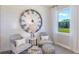 Cozy sitting area with comfortable chairs, a decorative clock, and abundant natural light from a window at 1671 Ruby Ln, Lake Alfred, FL 33850