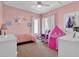 Cozy bedroom with soft pink walls, ceiling fan, and two windows with bright natural light at 2410 Berkshire Ct, Kissimmee, FL 34746