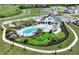 Aerial view of the community pool area featuring seating, pool, grassy area and a playground near neighborhood homes at 288 Woodsage Pl, Lake Alfred, FL 33850