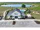 An aerial view of the community clubhouse, pool, playground and parking lot with a pond in the background at 288 Woodsage Pl, Lake Alfred, FL 33850