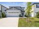 Charming two-story home with a two-car garage, landscaped yard, and a welcoming entrance, perfect for Gathering living at 288 Woodsage Pl, Lake Alfred, FL 33850