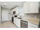 Bright kitchen with stainless steel appliances, white cabinets and stone countertops at 288 Woodsage Pl, Lake Alfred, FL 33850