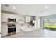 Bright kitchen with stainless steel appliances, white cabinets and stone countertops at 288 Woodsage Pl, Lake Alfred, FL 33850