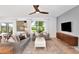 Bright living room featuring modern furniture, a ceiling fan and large windows offering natural light at 288 Woodsage Pl, Lake Alfred, FL 33850