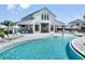 Stunning pool beside the community center with tables, umbrellas, and lounge chairs at 288 Woodsage Pl, Lake Alfred, FL 33850