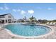 Community pool with lounge chairs and views of the clubhouse in a well-maintained area at 288 Woodsage Pl, Lake Alfred, FL 33850