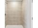 Close up shot of a tiled shower showcasing neutral-toned tiles and modern shower head at 288 Woodsage Pl, Lake Alfred, FL 33850