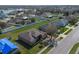 Aerial view of a home with a well-manicured lawn and a paved driveway in a neighborhood at 3890 Wood Thrush Dr, Kissimmee, FL 34744