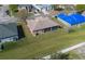 Aerial view of a home with a screened-in back porch and a sprawling lawn at 3890 Wood Thrush Dr, Kissimmee, FL 34744