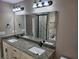 Double sink vanity with granite countertops, modern lighting, and updated hardware in bathroom at 1260 Buckeye Ne Rd, Winter Haven, FL 33881