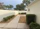 Private backyard features a manicured landscape with stone mulch, a privacy wall, and lush shrubbery at 1353 Lajolla Cir, The Villages, FL 32159