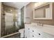 Modern bathroom boasts a glass-enclosed shower with stone tile floor and white vanity with bright lighting at 1353 Lajolla Cir, The Villages, FL 32159