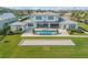 Aerial view of the estate showcasing manicured lawn, bocce court and stunning blue pool at 472 Desoto Dr, New Smyrna Beach, FL 32169
