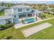 Aerial view of the estate showcasing manicured lawn, bocce court and stunning blue pool at 472 Desoto Dr, New Smyrna Beach, FL 32169