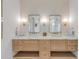 A bright bathroom features a double sink vanity with marble counters, drawers and mosaic tile walls at 472 Desoto Dr, New Smyrna Beach, FL 32169