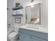 A blue and white bathroom with floating shelves for linen storage at 472 Desoto Dr, New Smyrna Beach, FL 32169