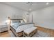 A light-filled bedroom with wood floors and a bench at the foot of the bed at 472 Desoto Dr, New Smyrna Beach, FL 32169