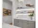 Wet bar area with custom gray cabinetry, open shelving and tasteful decor, providing extra storage at 472 Desoto Dr, New Smyrna Beach, FL 32169