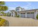 Stately home exterior with a three-car garage, complimented by lush landscaping for refined elegance at 472 Desoto Dr, New Smyrna Beach, FL 32169