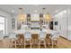 Spacious kitchen island with white quartz countertops and stylish wicker chairs, perfect for casual dining and entertaining at 472 Desoto Dr, New Smyrna Beach, FL 32169