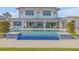 A refreshing pool features vibrant blue tiling and multiple seating areas for entertaining guests at 472 Desoto Dr, New Smyrna Beach, FL 32169