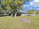 Spacious backyard with mature trees, a concrete fire pit, and a well-maintained lawn at 917 E Valencia St, Lakeland, FL 33805