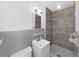Modern bathroom with light-colored tile features a shower, sink, toilet, and light fixture at 917 E Valencia St, Lakeland, FL 33805