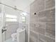 Modern bathroom with light-colored tile features a shower, sink, toilet, and window at 917 E Valencia St, Lakeland, FL 33805