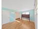 Light blue bedroom with wood floors and a neutral-toned, paneled accent wall at 917 E Valencia St, Lakeland, FL 33805