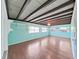 Bonus room with wooden floors, teal walls, exposed beams, and bright natural light at 917 E Valencia St, Lakeland, FL 33805