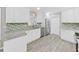 Modern kitchen featuring white cabinetry, stainless steel appliances, and stylish backsplash at 917 E Valencia St, Lakeland, FL 33805