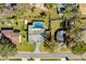 Aerial of home and yard featuring a sparkling screened-in pool and well-maintained landscaping at 1730 John Arthur Way, Lakeland, FL 33803