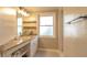 A serene bathroom with a granite vanity, open shelving, and a window at 1730 John Arthur Way, Lakeland, FL 33803