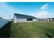 Expansive, grassy backyard with solar panels on roof and white privacy fence at 891 Galloway St, Lake Alfred, FL 33850