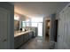 Bright bathroom featuring double sinks, a glass-enclosed shower, and linen storage at 891 Galloway St, Lake Alfred, FL 33850