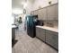 Modern kitchen with gray cabinets, stainless steel refrigerator, and white counters at 891 Galloway St, Lake Alfred, FL 33850