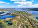 Breathtaking aerial view capturing a scenic landscape with interconnected lakes and a winding road through wooded areas at 17416 Magnolia Island Blvd, Clermont, FL 34711