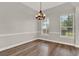 Dining room featuring wood floors, contemporary chandelier, chair rail and natural light from two windows at 17416 Magnolia Island Blvd, Clermont, FL 34711