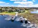 Aerial view of private boat dock with boat house on a calm, beautiful lake at 17416 Magnolia Island Blvd, Clermont, FL 34711