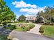 Beautiful home exterior featuring a circular driveway, lush landscaping, and a welcoming porch at 17416 Magnolia Island Blvd, Clermont, FL 34711