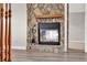 Close-up of a stone fireplace with a wooden mantel and decorative fire tools at 17416 Magnolia Island Blvd, Clermont, FL 34711