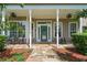 Charming front porch with decorative door, seating area, and beautiful landscaping at 17416 Magnolia Island Blvd, Clermont, FL 34711