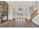 Spacious living room with wood floors, stone fireplace, and a wall of French doors leading to the pool area at 17416 Magnolia Island Blvd, Clermont, FL 34711