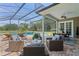 Relaxing screened patio area featuring comfortable wicker furniture and pool access at 17416 Magnolia Island Blvd, Clermont, FL 34711