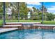 Screened pool with waterfall feature surrounded by lush landscaping at 17416 Magnolia Island Blvd, Clermont, FL 34711