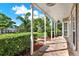 Covered porch with stone flooring and a view of the well-manicured front yard at 17416 Magnolia Island Blvd, Clermont, FL 34711