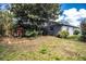 Landscaped backyard featuring garden beds and plenty of trees around the home's gray painted exterior at 4739 Tierra Alta Ct, Lakeland, FL 33813